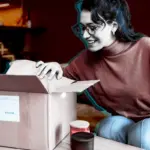 Smiling woman opening a delivery box