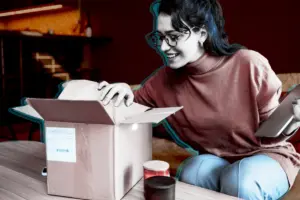 Smiling woman opening a delivery box
